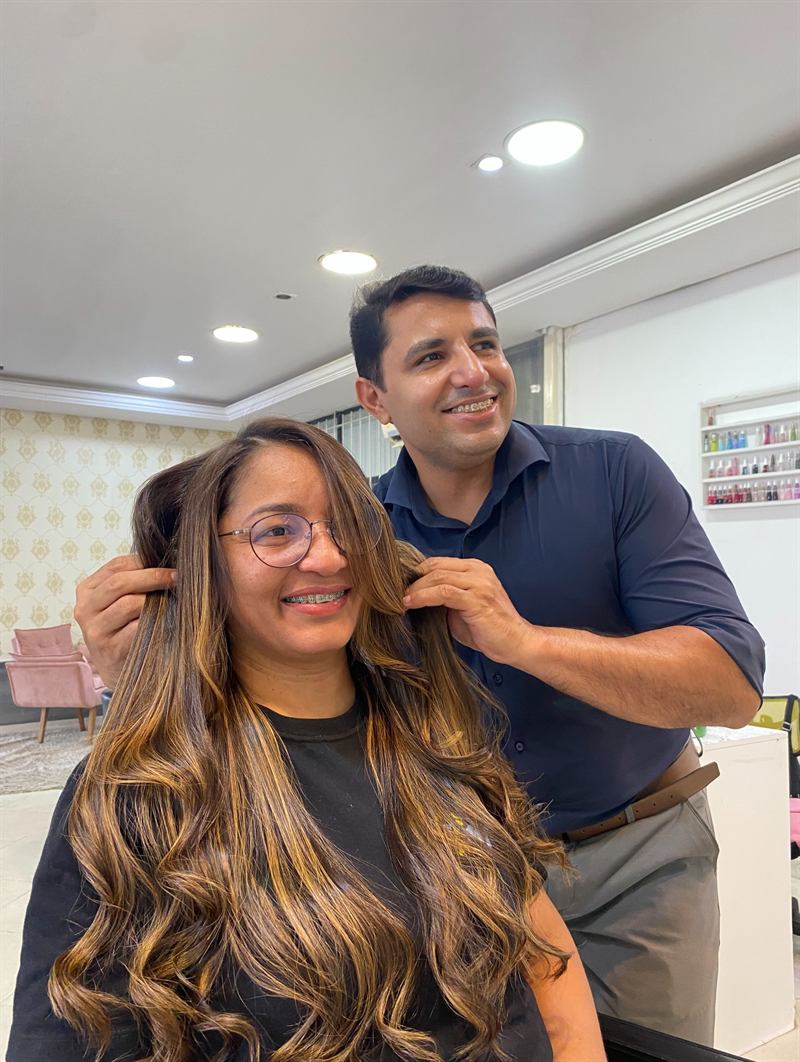 Roberto ajeitando o cabelo de uma cliente depois do atendimento