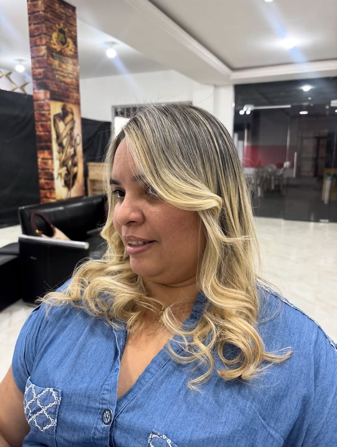 Loiro claro com franja lateral e cachos nas pontas, feito no salão