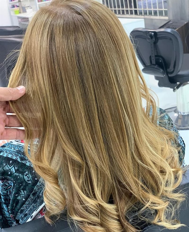 Cabelo loiro iluminado com pontas onduladas