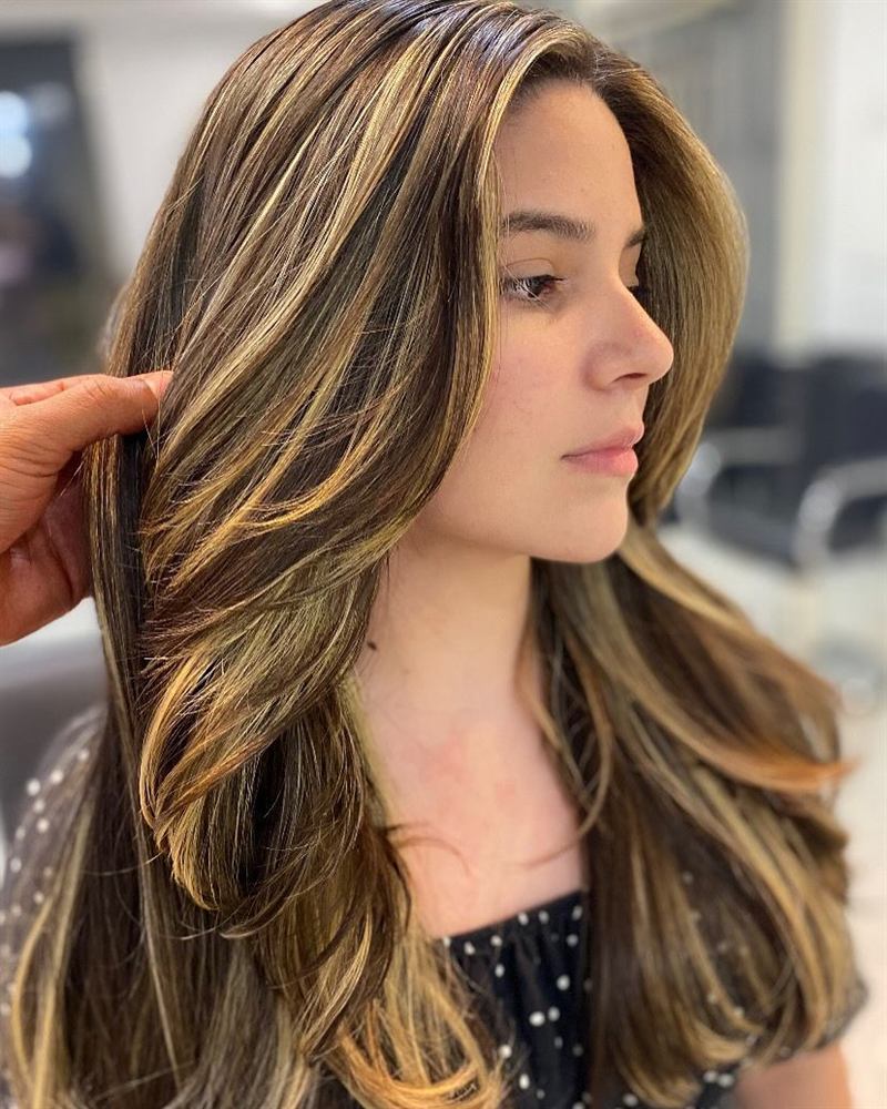 Mechas douradas com corte em camadas, de perfil